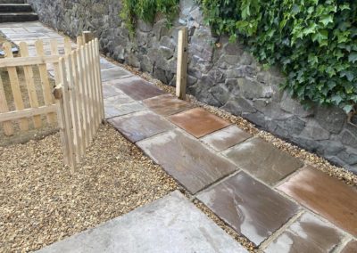 Picket fence and gate with new tiled pathway and malvern stone wall