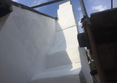 Freshly rendered chimney breast with white paint