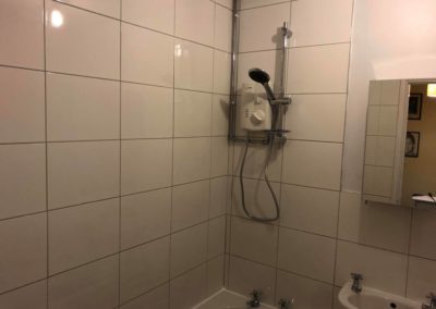 New shower unit on white tiles