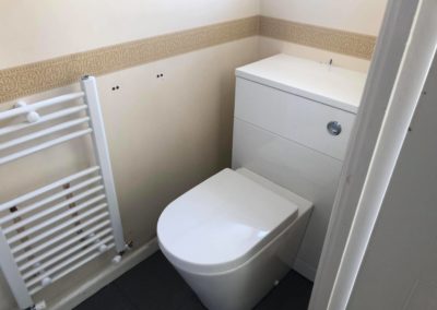Fitted toilet with white towel rail