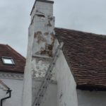 Chimney breast with loose brickwork and peeling paint