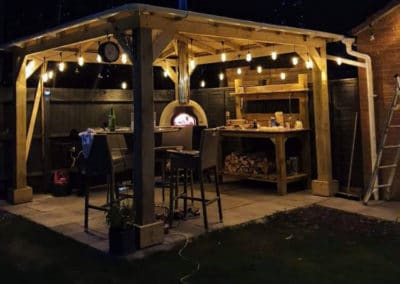 Gazebo with hanging lights and pizza oven